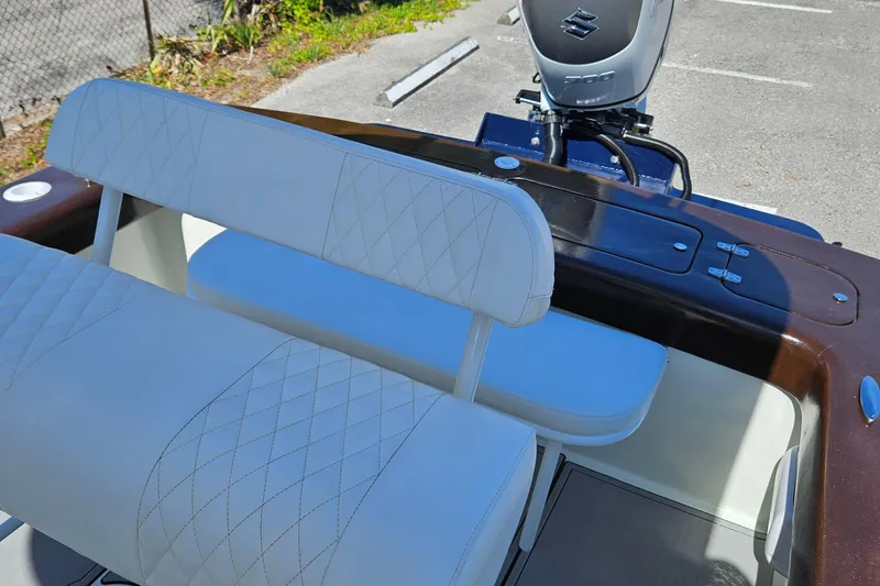 Slide: The Image of Carolina Classic 25 boat interior, 2023 model, featuring white cushioned seating and Suzuki outboard motor. - 12