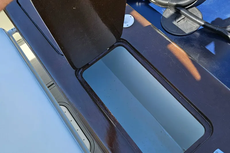 Slide: The Image of Open storage compartment on a 2023 Carolina Classic 25 boat. - 13