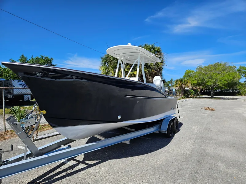 Slide: The Image of 2023 Carolina Classic 25 boat on a trailer under a clear blue sky. - 3