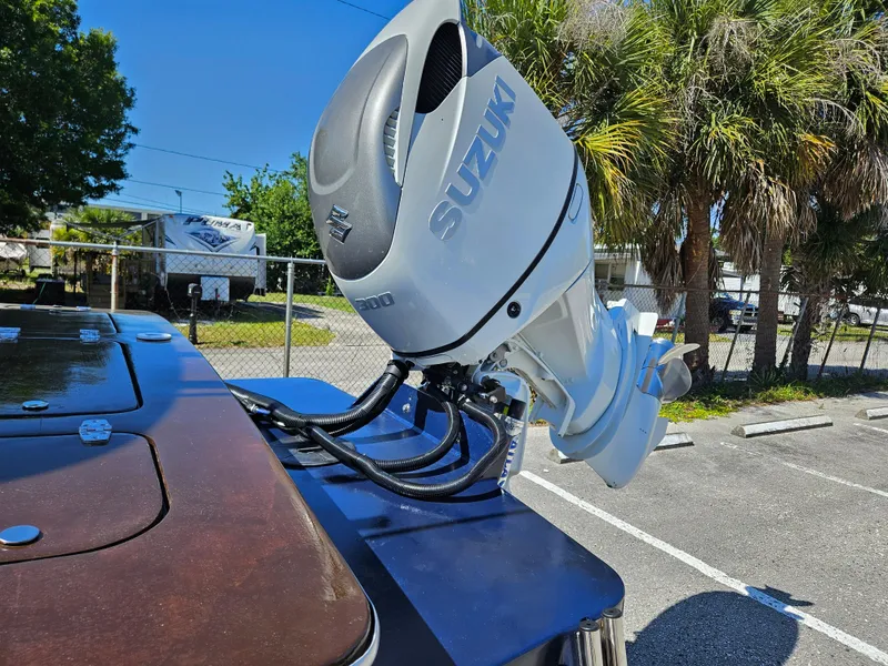 Slide: The Image of 2023 Carolina Classic 25 boat with Suzuki outboard motor in a parking lot. - 6