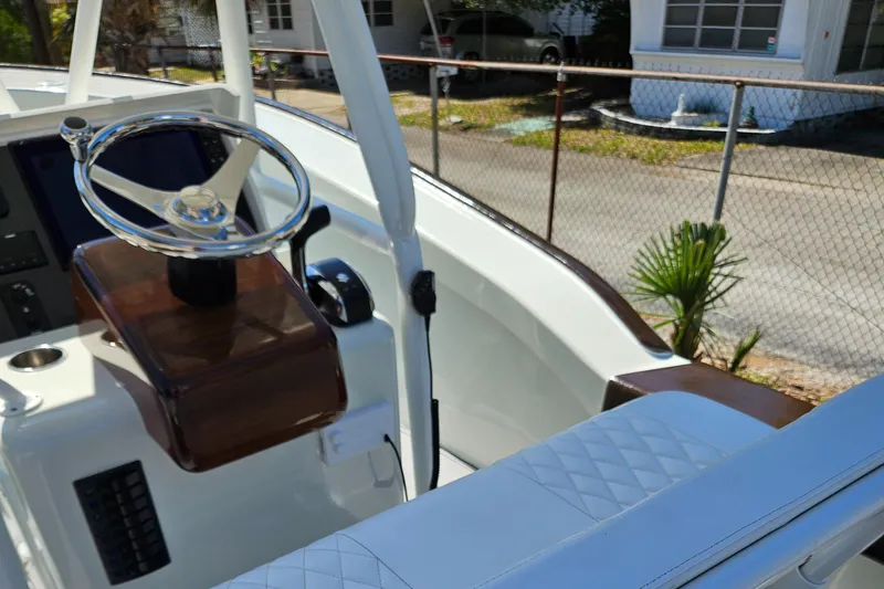 Slide: The Image of 2023 Carolina Classic 25 boat interior with steering wheel and seating. - 8