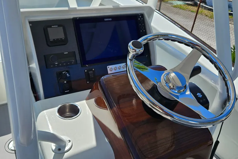 Slide: The Image of 2023 Carolina Classic 25 boat dashboard with steering wheel and navigation system. - 9