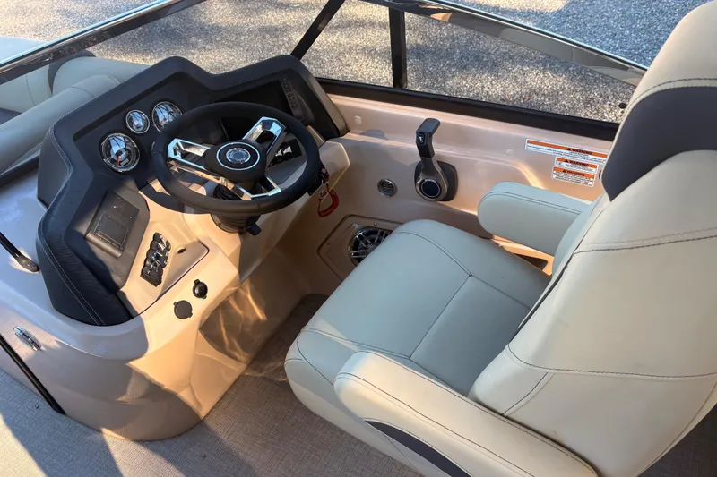 Slide: The Image of Interior of 2022 Avalon Excalibur Elite Windshield boat, featuring steering wheel and captain's chair. - 11