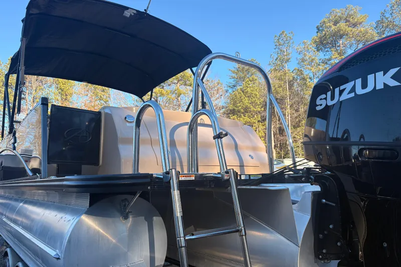 Slide: The Image of 2022 Avalon Excalibur Elite Windshield boat with Suzuki engine, ladder, and canopy in a wooded area. - 6