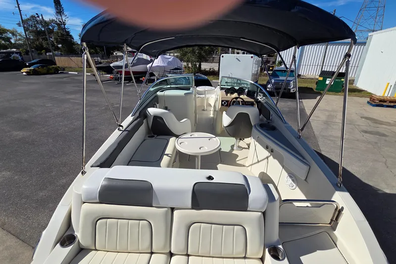 Slide: The Image of 2010 Sea Ray 260 Sundeck boat interior with seating and canopy in a parking area. - 31