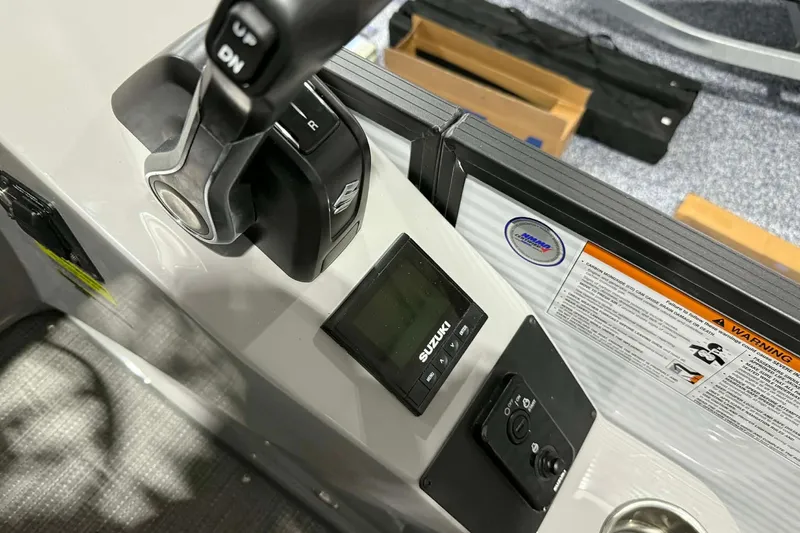 Slide: The Image of 2026 Manitou Encore SL 230 SHP boat controls with Suzuki display and throttle lever. - 16
