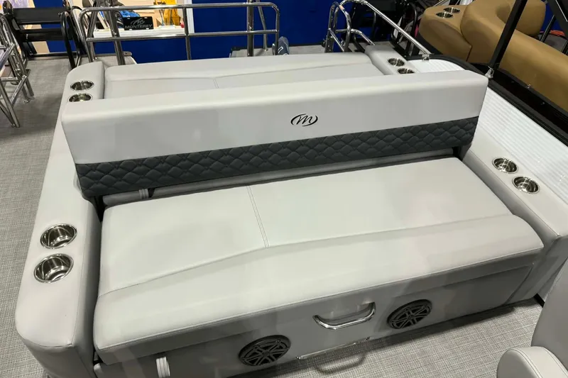 Slide: The Image of Luxurious seating on 2026 Manitou Encore SL 230 SHP pontoon boat, featuring cup holders and speakers. - 18