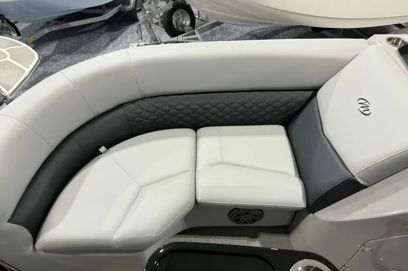 Slide: The Image of Luxurious seating on 2026 Manitou Encore SL 230 SHP boat, featuring quilted upholstery and integrated speaker. - 5
