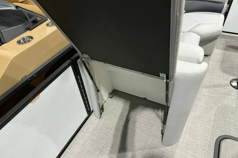 Slide: The Image of 2026 Manitou Encore SL 230 SHP interior with open storage compartment and seating. - 8