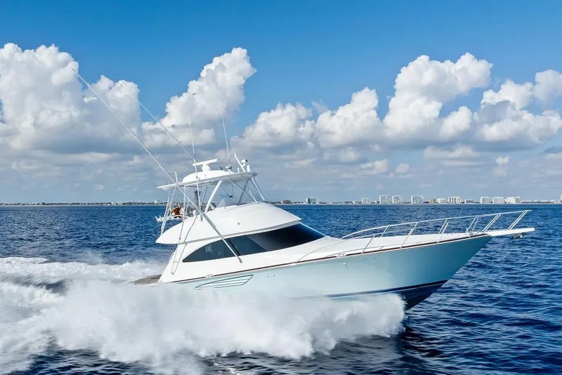 Slide: The Image of 2022 Viking 48 Convertible yacht cruising on open water under blue sky. - 17