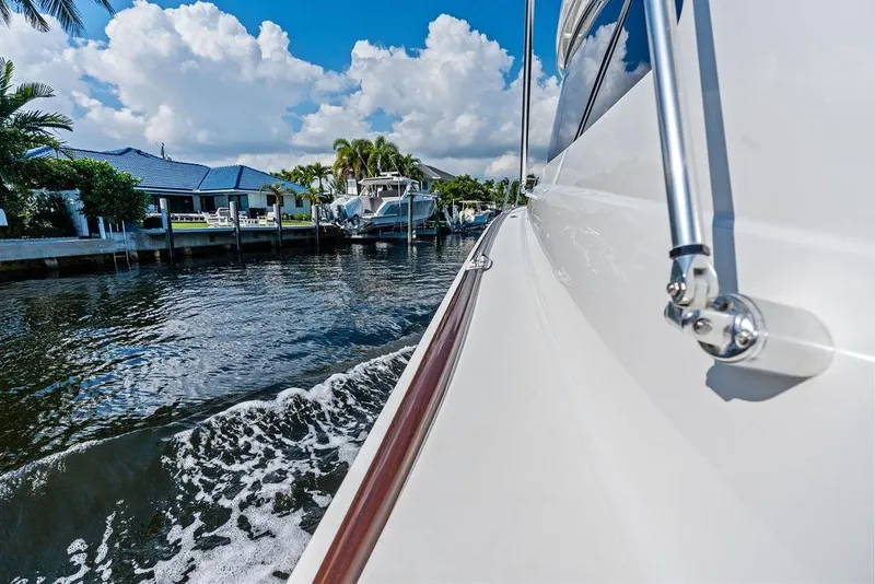 Slide: The Image of 2022 Viking 48 Convertible yacht cruising along a scenic waterfront. - 31