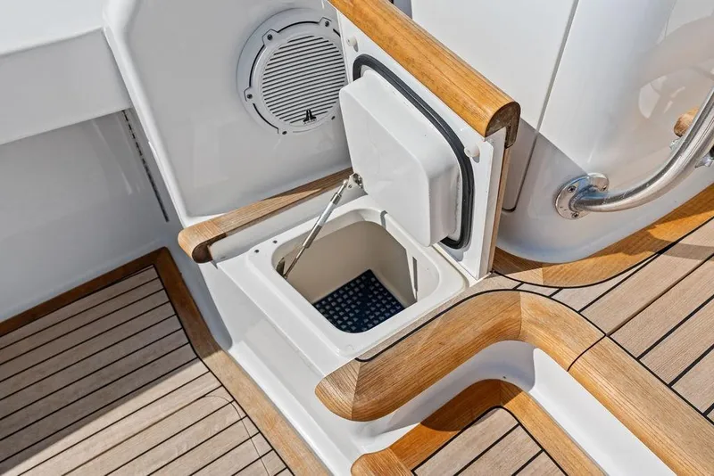 Slide: The Image of 2022 Viking 48 Convertible yacht deck with open storage compartment and speaker. - 35