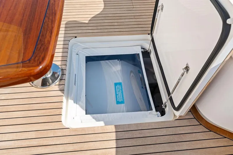 Slide: The Image of Open hatch on 2022 Viking 48 Convertible yacht deck, showcasing storage compartment. - 38