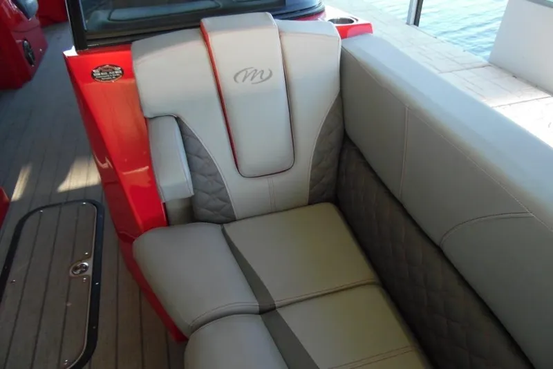 Slide: The Image of 2023 Manitou 25 XT RFX boat interior with red accents and quilted seating. - 11