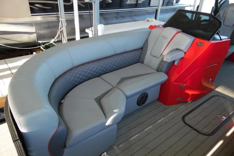 Slide: The Image of 2023 Manitou 25 XT RFX boat interior with gray seating and red accents. - 12