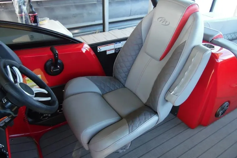 Slide: The Image of Captain's seat of 2023 Manitou 25 XT RFX boat, featuring luxurious gray and red upholstery. - 15