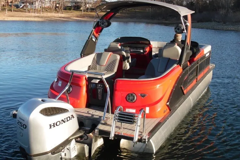 Slide: The Image of 2023 Manitou 25 XT RFX pontoon boat with Honda engine on a lake. - 3