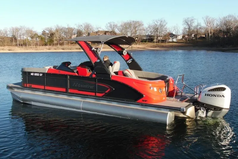 Slide: The Image of 2023 Manitou 25 XT RFX pontoon boat with Honda engine on a calm lake. - 5