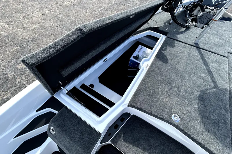 Slide: The Image of Open storage compartment on 2026 Skeeter ZXE20 boat, featuring carpeted interior. - 10