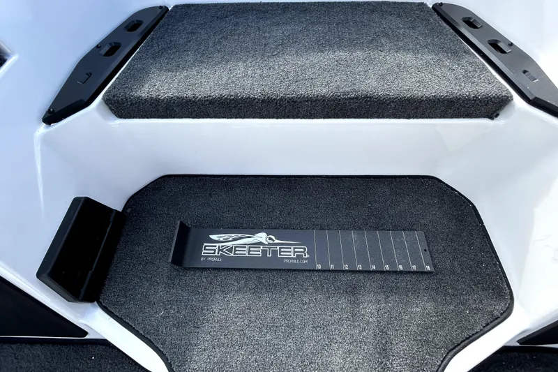 Slide: The Image of Interior of 2026 Skeeter ZXE20 boat with carpeted steps and branded measuring tool. - 19