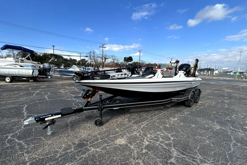 Slide: The Image of 2026 Skeeter ZXE20 boat on trailer in parking lot under blue sky. - 2