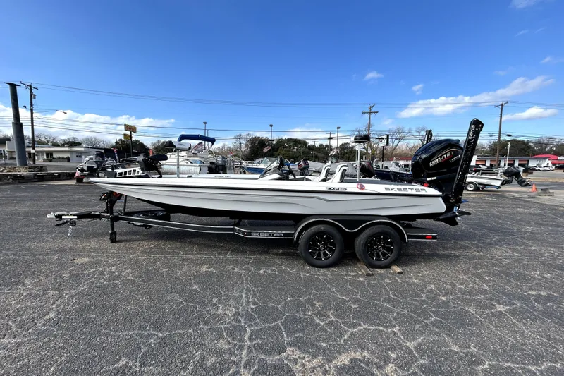 Slide: The Image of 2026 Skeeter ZXE20 boat with dual axle trailer, parked outdoors under a clear blue sky. - 3
