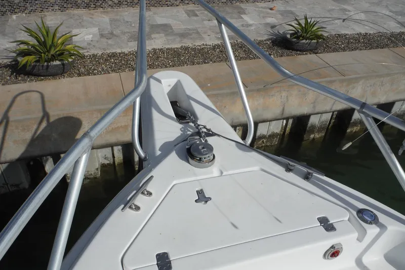 Slide: The Image of Bow of 1999 Intrepid 289 Center Console boat docked by a concrete pier. - 18