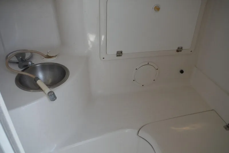 Slide: The Image of Interior of a 1999 Intrepid 289 Center Console boat with sink and storage compartment. - 28