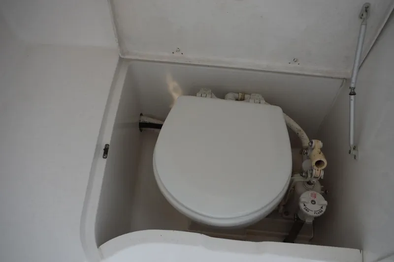 Slide: The Image of 1999 Intrepid 289 Center Console boat toilet compartment with flush controls. - 29