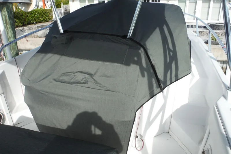 Slide: The Image of 1999 Intrepid 289 Center Console with protective cover, docked in a marina. - 53