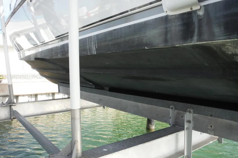 Slide: The Image of 1999 Intrepid 289 Center Console boat hull on lift over water. - 57