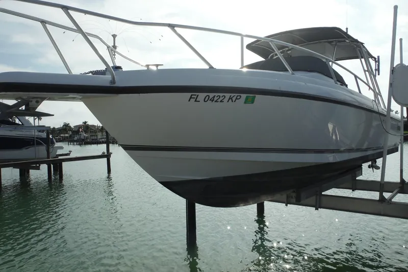 Slide: The Image of 1999 Intrepid 289 Center Console boat docked on lift in sunny marina. - 59