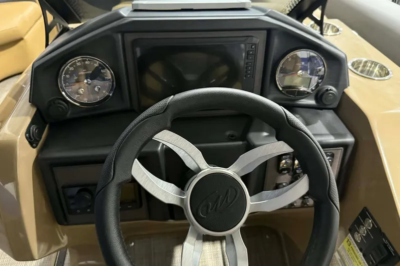 Slide: The Image of Steering console of 2026 Manitou Encore VP 230 pontoon boat, featuring modern gauges and controls. - 10