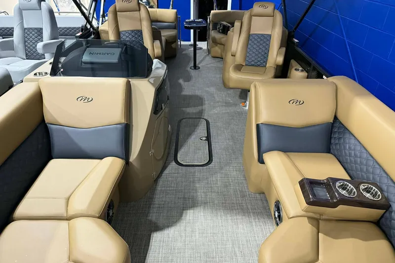 Slide: The Image of Luxurious interior of 2026 Manitou Encore VP 230 pontoon boat with tan and gray seating. - 2