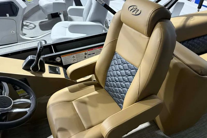 Slide: The Image of Luxurious captain's chair in 2026 Manitou Encore VP 230 boat, featuring tan and gray upholstery. - 9