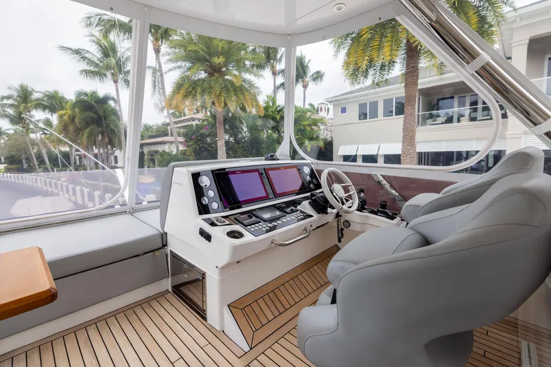 Slide: The Image of Luxurious 2019 Sunseeker 76 yacht helm with modern controls and palm tree view. - 10