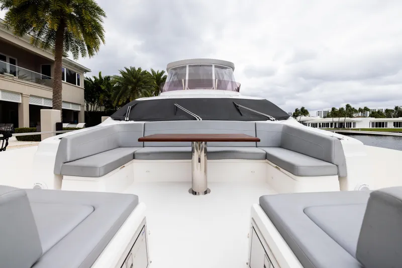 Slide: The Image of Luxurious 2019 Sunseeker 76 yacht with spacious outdoor seating and table, docked near palm trees. - 55