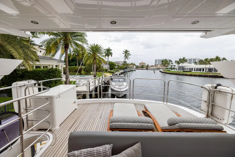 Slide: The Image of Luxurious 2019 Sunseeker 76 yacht deck with lounge chairs, overlooking a scenic waterfront. - 7