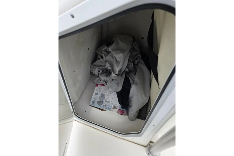 Slide: The Image of Storage compartment in 2016 Sea Fox 22XTR Viper boat with clothes and a box. - 19