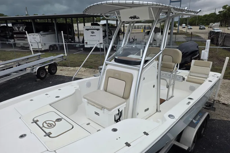 Slide: The Image of 2016 Sea Fox 22XTR Viper boat with seating and T-top, parked near RVs. - 3