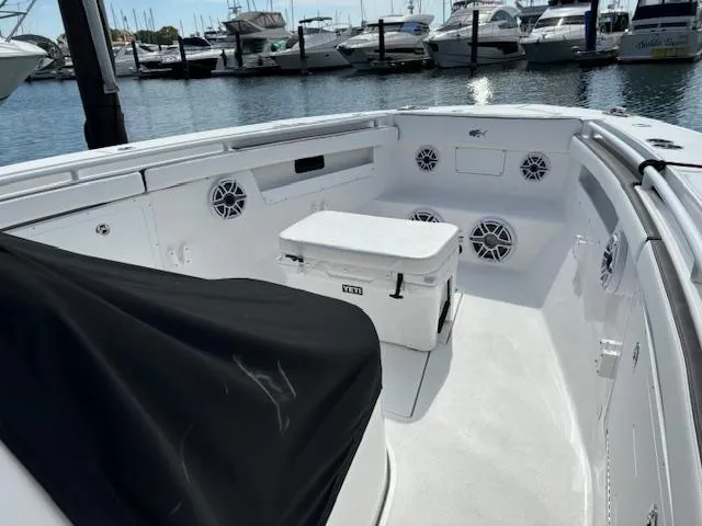 Slide: The Image of 2025 Crevalle 33 CTF boat interior with speakers and cooler, docked at marina. - 13