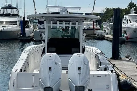 Slide: The Image of 2025 Crevalle 33 CTF boat docked in marina, featuring dual outboard engines. - 6