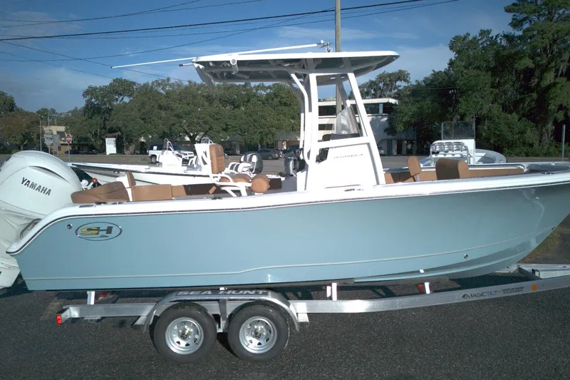The Image of 2026 Sea Hunt Ultra 229 boat on trailer, featuring Yamaha engine, parked outdoors. - 0