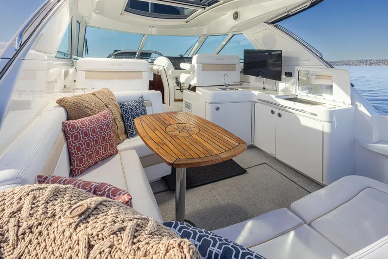 Slide: The Image of Luxurious 2010 Sea Ray Sundancer yacht interior with plush seating and elegant wooden table. - 11