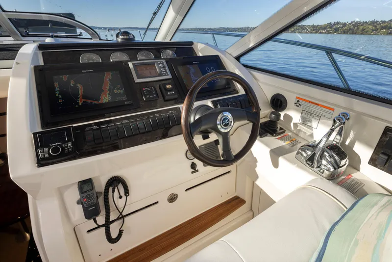 Slide: The Image of 2010 Sea Ray Sundancer helm with navigation screens and controls on a sunny day. - 15