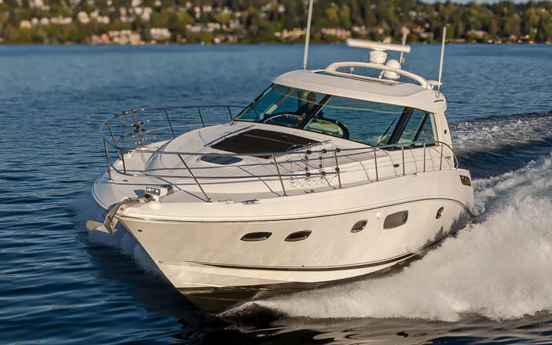 Slide: The Image of 2010 Sea Ray Sundancer cruising on a serene lake with lush green shoreline. - 27