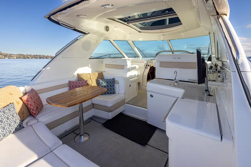 Slide: The Image of Luxurious 2010 Sea Ray Sundancer yacht interior with seating, table, and scenic water view. - 8