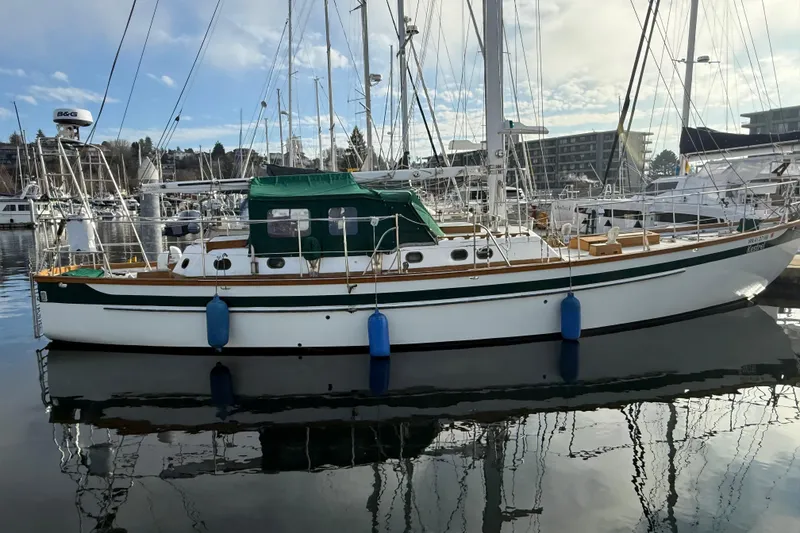 The Image of Sailboat docked in marina, HMMD 46 model, 1990, with green canopy and blue fenders. - 1