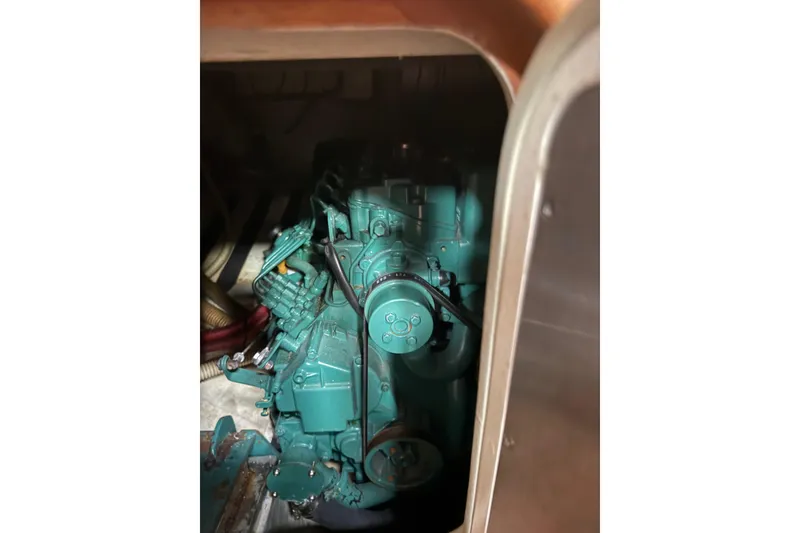 Slide: The Image of Engine compartment of a 1990 Custom 46, featuring a teal-colored engine. - 11