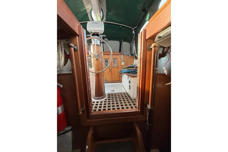 Slide: The Image of Interior view of a 1990 Custom 46 sailboat cockpit with wooden details and steering wheel. - 22
